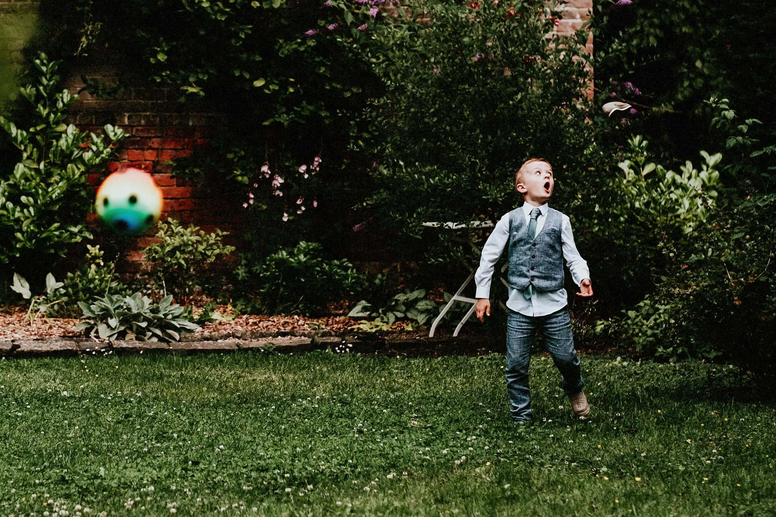 wedding photographer in edinburgh funny photo of little boy kicking a ball and his shoe flying off