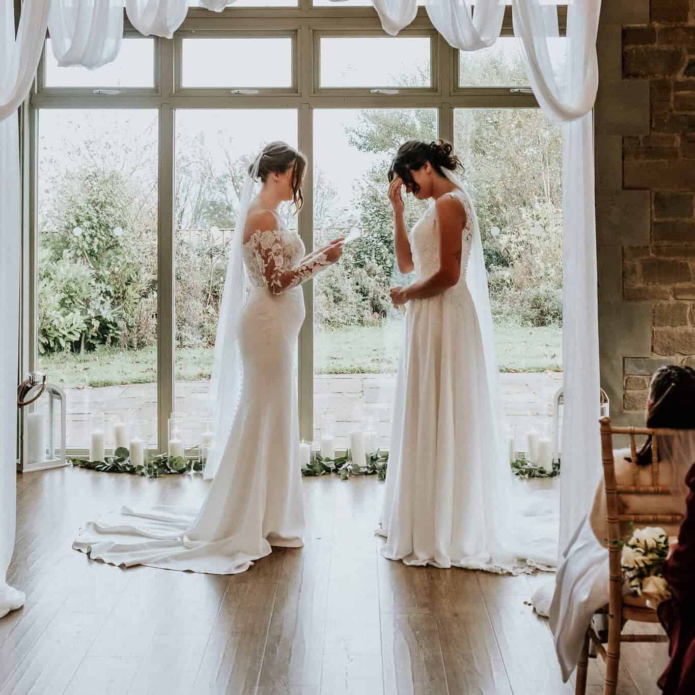 Tweo brides reading their vows by UK wedding photographer Andy Turner