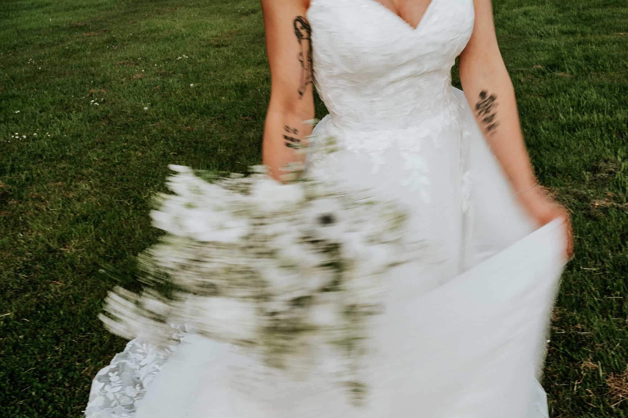 Bride swinging her bouquet to create motion blur