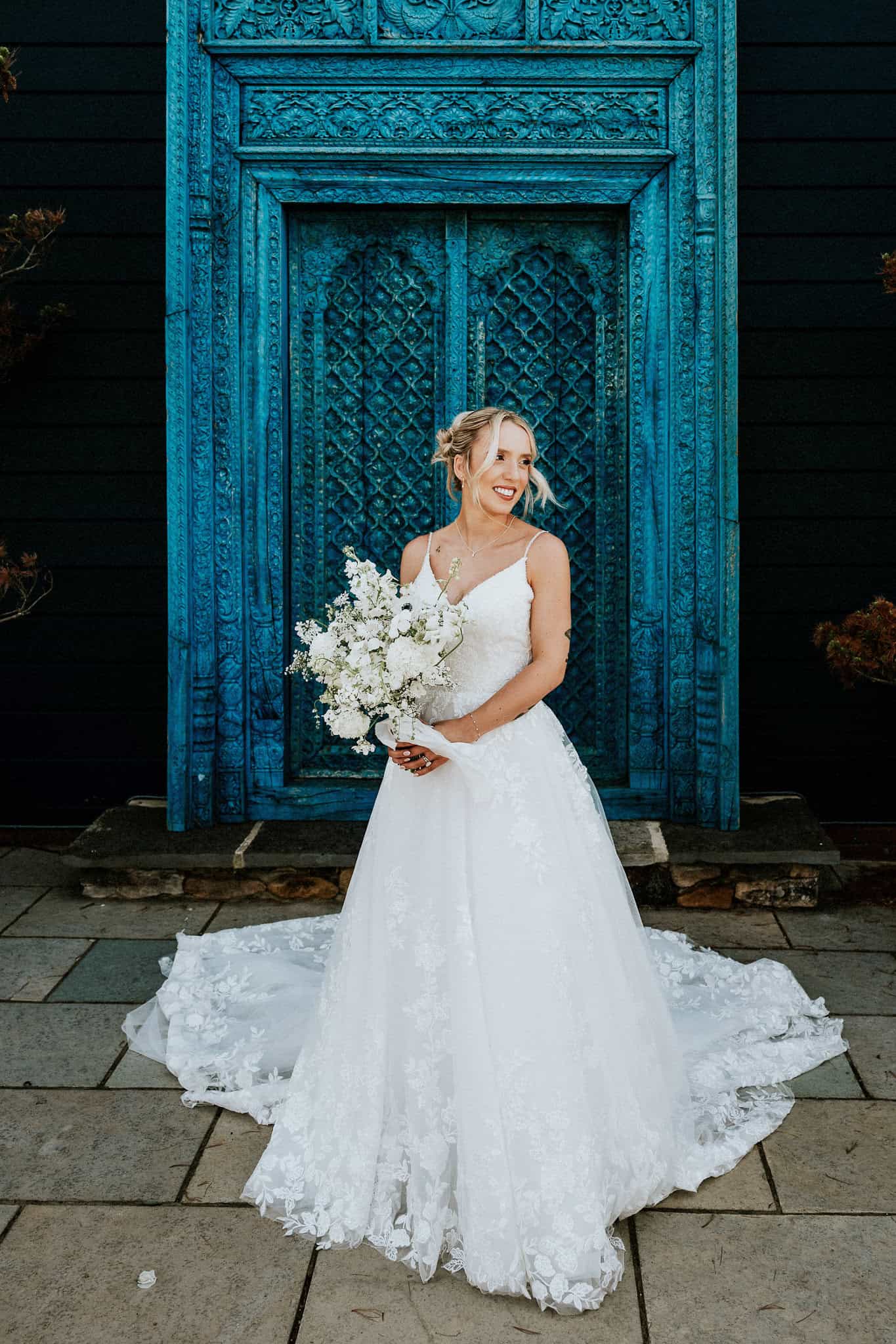 Bride in front of blue door by Andy Turner